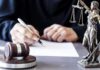 Seven Women Crush Powerful Mayor Judge writing at desk with gavel and Lady Justice statue