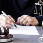 Seven Women Crush Powerful Mayor Judge writing at desk with gavel and Lady Justice statue