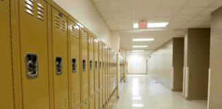 Row of yellow school lockers in an empty hallway