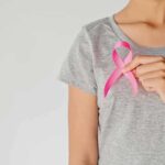 Shock Test Update: Trump Family Bombshell Person holding a pink ribbon on a gray shirt