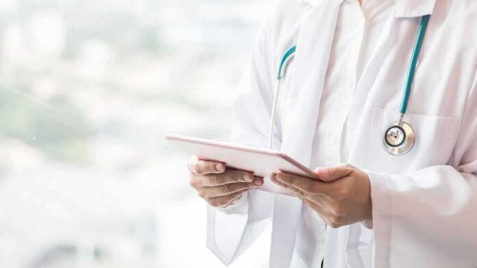 shutterstock_1034282797 Doctor with stethoscope using a tablet