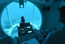 submarine interior with pilot viewing seafloor through large window