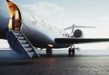 Private jet on tarmac with open door and boarding stairs