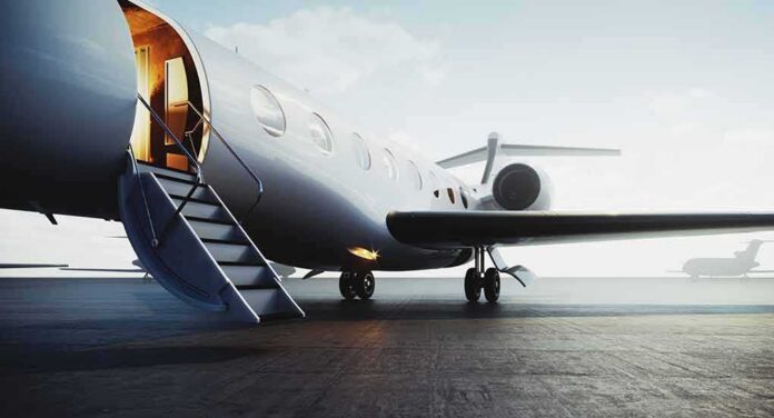 shutterstock_1500547733 Private jet on tarmac with open door and boarding stairs