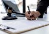 Texas Targets ChatGPT – Kids Locked Out? Hand signing legal document beside gavel and laptop